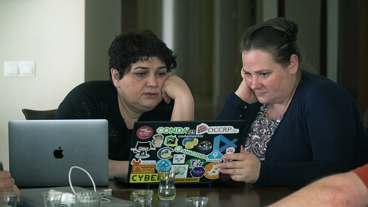 Miranda Patrucic and Khadija Ismayilova sit together looking at a laptop