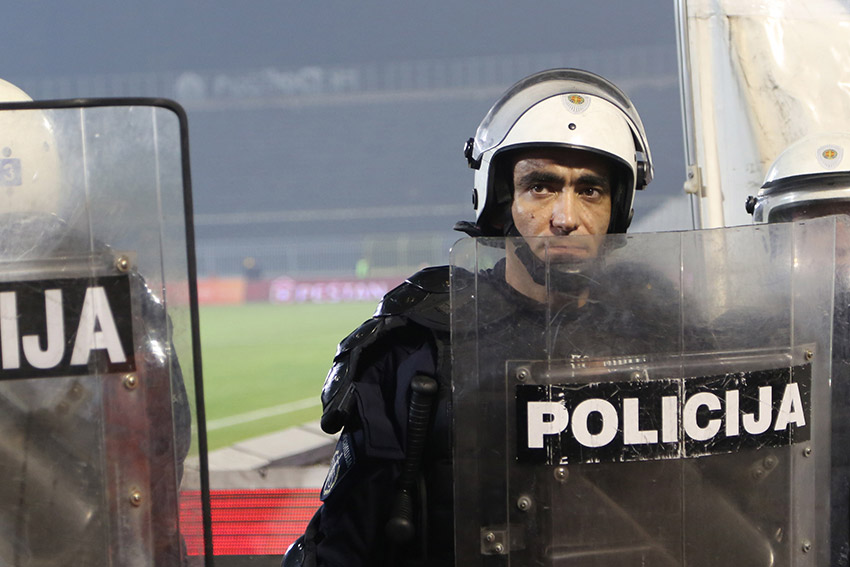 A riot policeman stands guard at a Belgrade football match (Photo: Aubrey Belford)