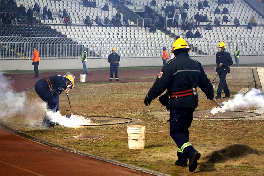 Firemen extinguish flares thrown onto the field by FK Partizan supporters (Photo: Aubrey Belford)