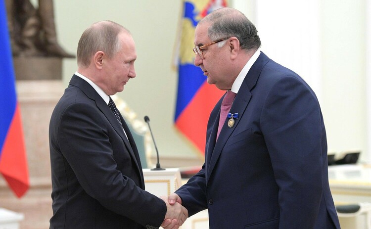 Usmanov and Putin shake hands.