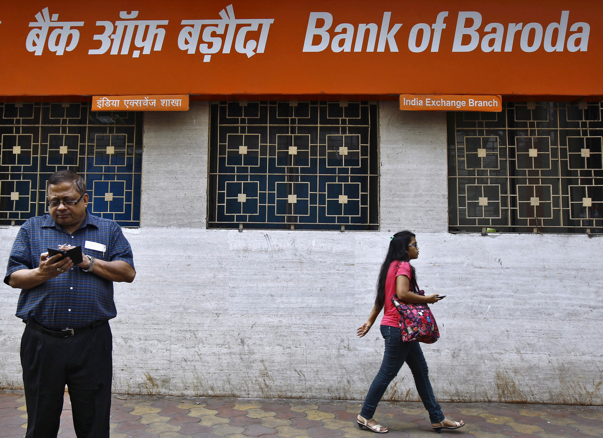 A commuter walks past an advertisement of Bank of Baroda in Kolkata, India, November 2015. The bank was once India's second-biggest state-run lender by assets. Credit: Rupak de Chowdhuri / Reuters