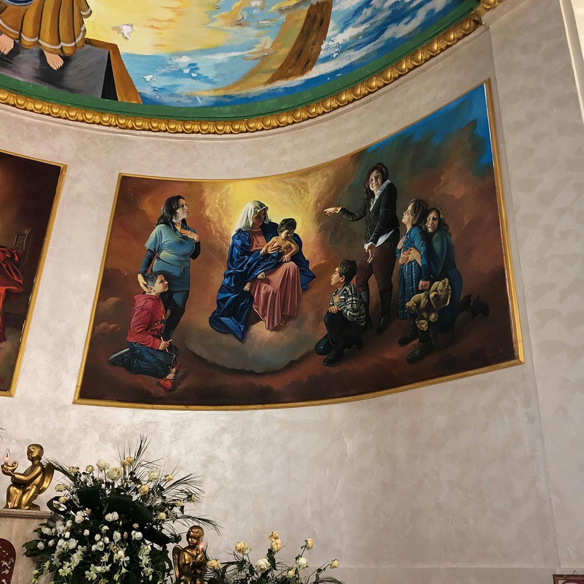 In one fresco commemorating the Duisburg massacre, the Virgin Mary is surrounded by mothers and their children from the feuding families, one holding a teddy bear. Photo by: Antonio Lemma