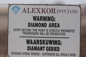 A sign from Alexkor Ltd with the words, Warning: Diamond Area. Entry beyond this point is strictly prohibited. Trespassers will be prosecuted.
