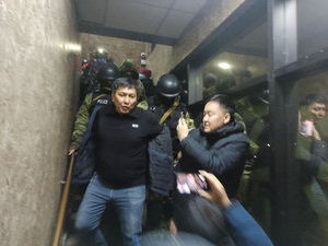 Police officers lead Bolot Temirov out in handcuffs