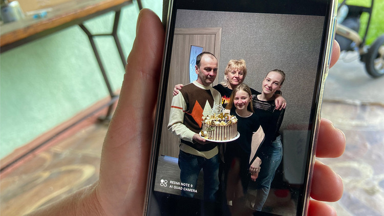 Vitaly Kibukevich’s widow shows a family photo