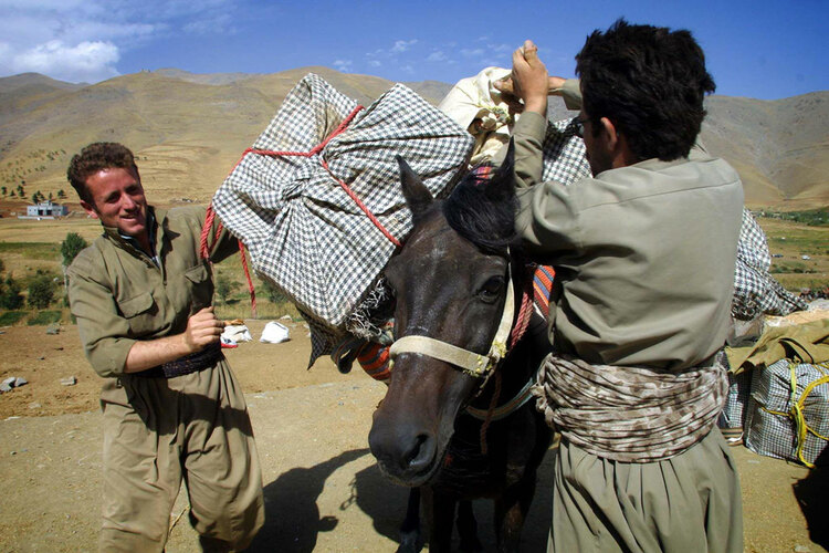 Kurdish smugglers load cigarettes onto a horse