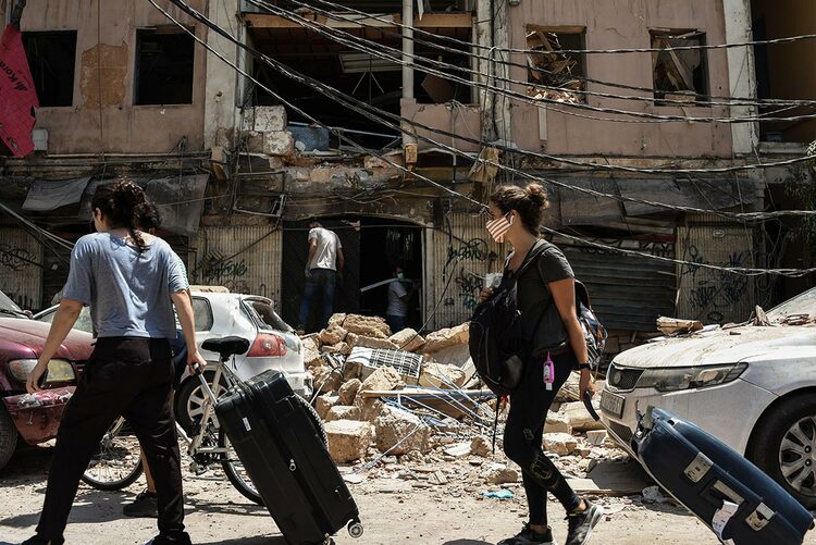 People are seen with suitcases leaving Beirut after the explosion