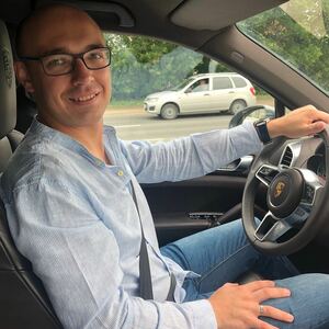 Novikov sits at the wheel of a Porsche