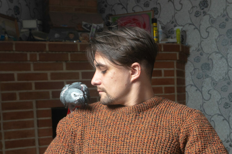 Stanislavas “Stas” Huzhiavichus sits with a bird perched on his shoulder