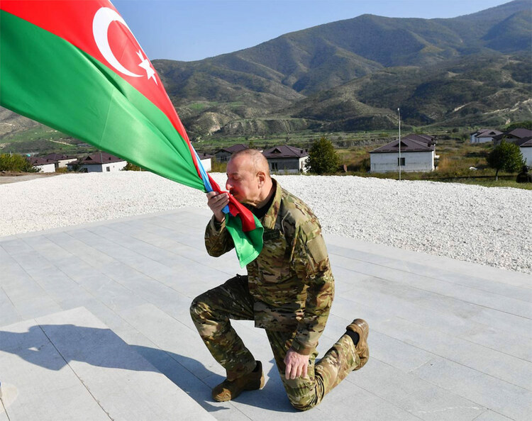 President Ilham Aliyev kisses an Azerbaijani flag