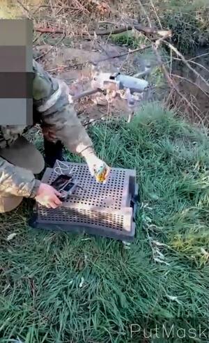 A Russian soldier attaches a grenade to a drone