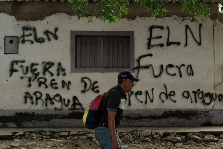 A person walks past graffiti in Cucuta
