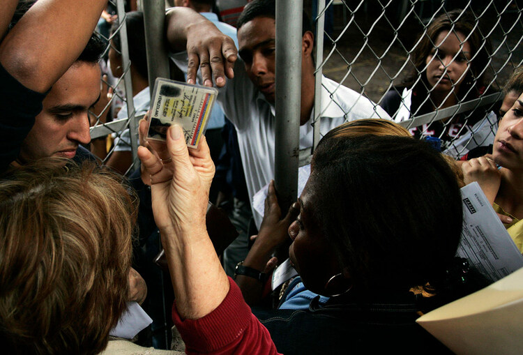 People wait in line outside the main office of the Foreign Currency Administration Commission in Caracas