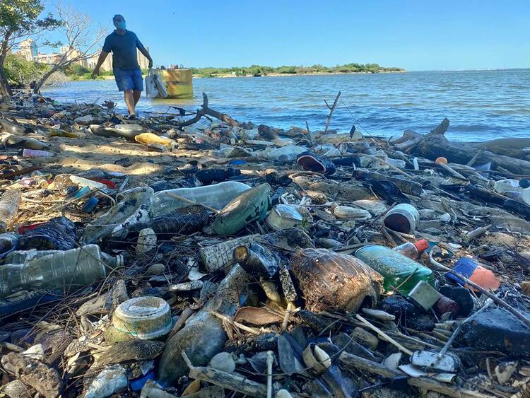 Garbage can be seen as a man walks along the shore of Lake Maracaibo