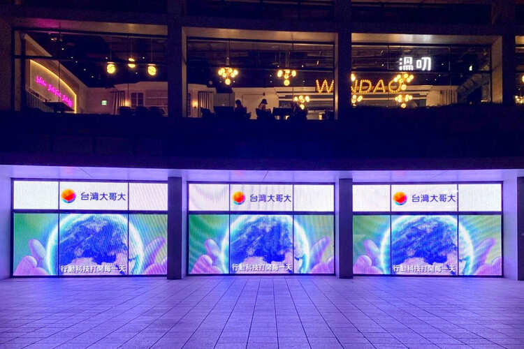 Brightly lit neo windows displaying Taiwan Mobile advertising.