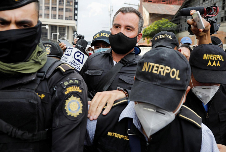 Alejandro Sinibaldi is escorted by members of Interpol