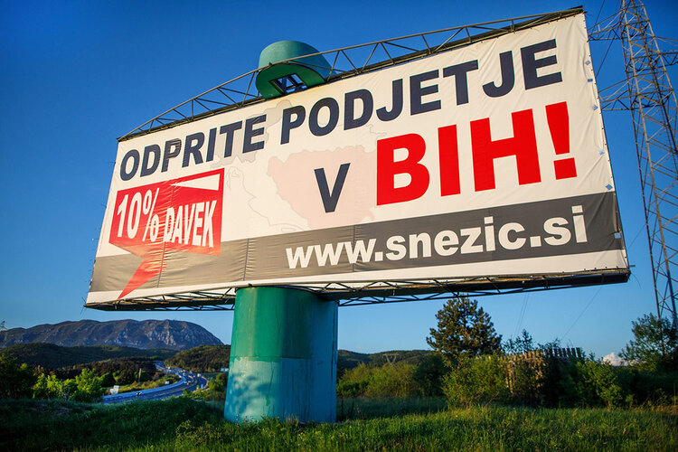 A billboard advertising Snezics company