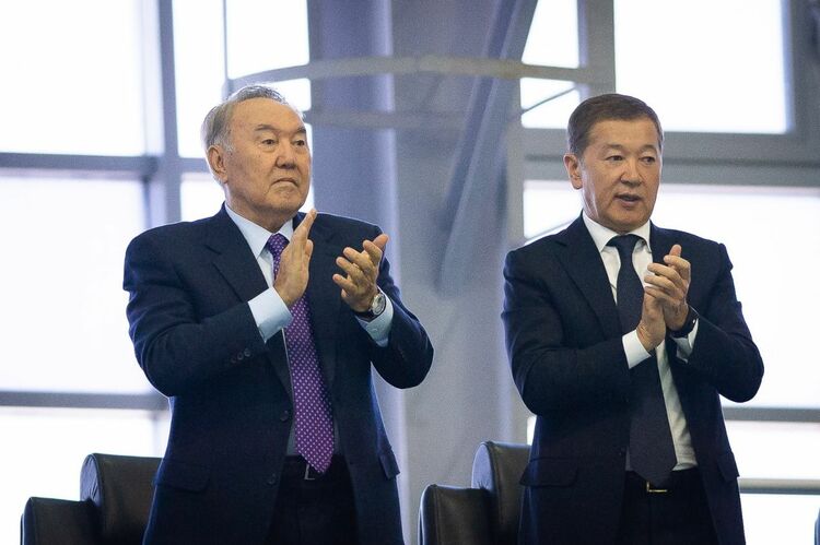 Nursultan Nazarbayev and Bulat Utemuratov clapping at a tennis match