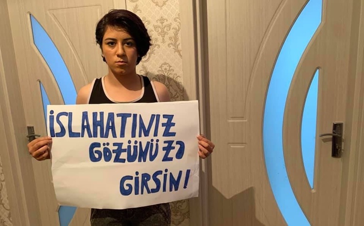 Fatima Movlamli holding up a placard