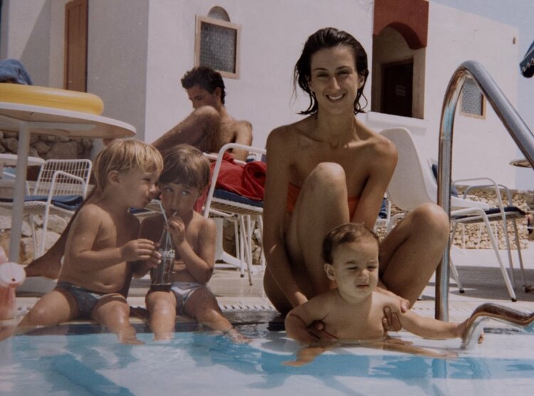 A family photo of Daphne Caruana Galizia with her three young sons by a swimming pool