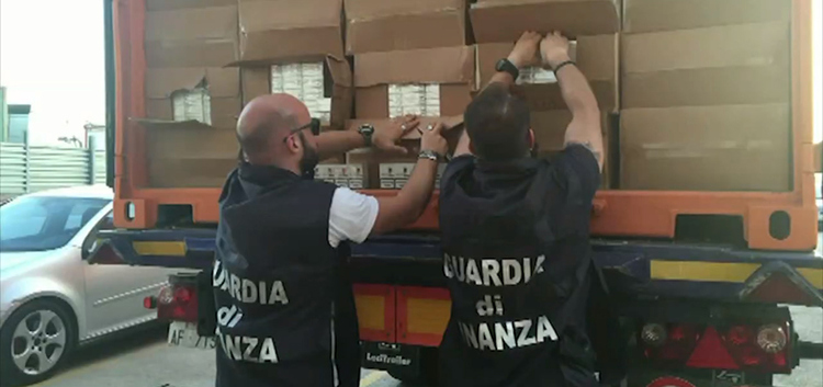 Two Italian police unloading cartons of cigarettes