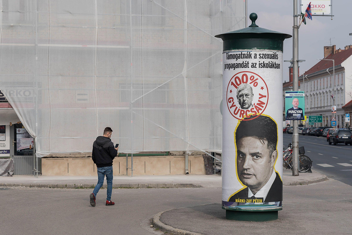 Man walks past an election poster