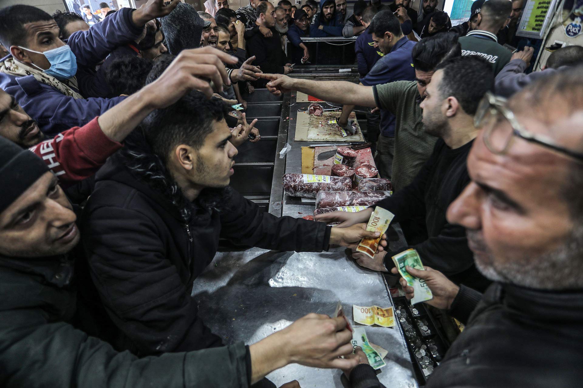 Palestinians rush to buy frozen meat as it enters the Gaza Strip through the Kerem Shalom crossing