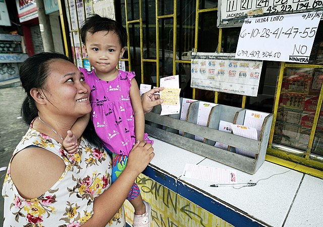 A Fillipina mother holds her daughter after purchasing a lottery ticket in 2018, when the jackpot rose to over US$13 million