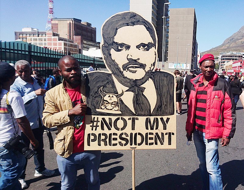 800px-Atul Gupta protest banner - Cape Town Zuma must fall