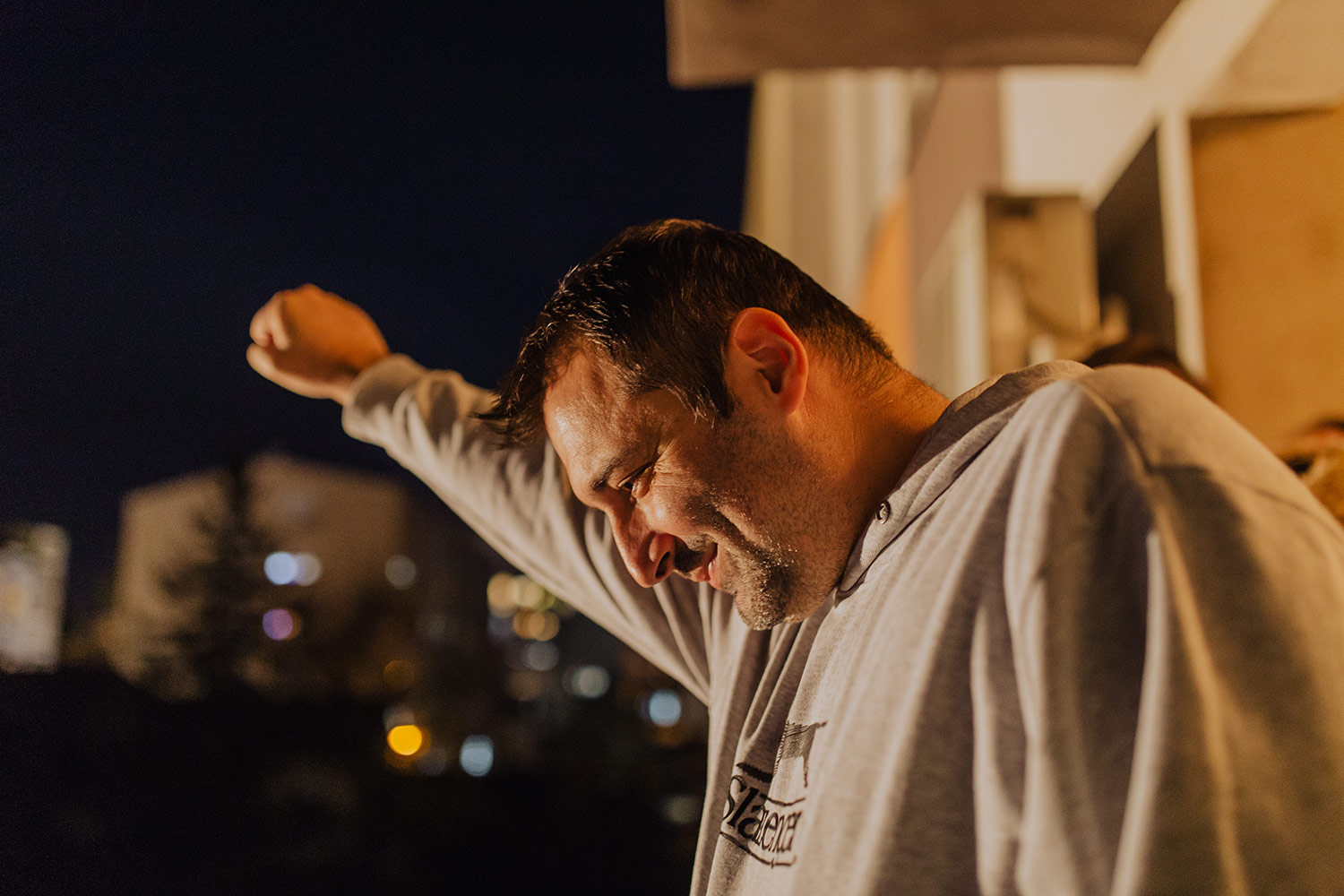 Whistleblower Aleksandar Obradović gestures to protesters demanding his release from a balcony of his home where he was held under house arrest. (Credit: Djordje Djokovic)