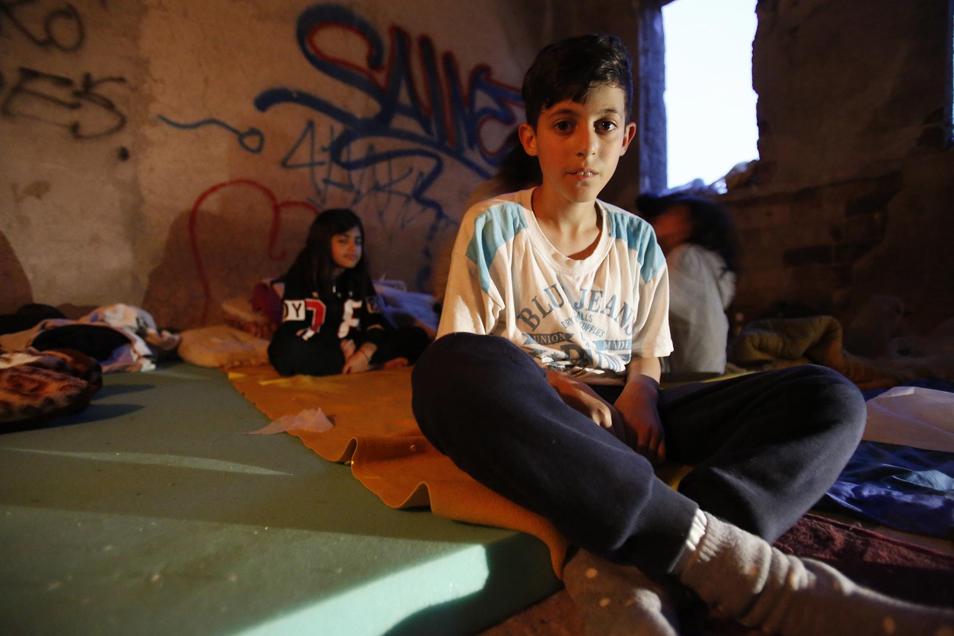 A young Afghan boy sits on a makeshift bed in the northwestern Bosnian town of Bihac.